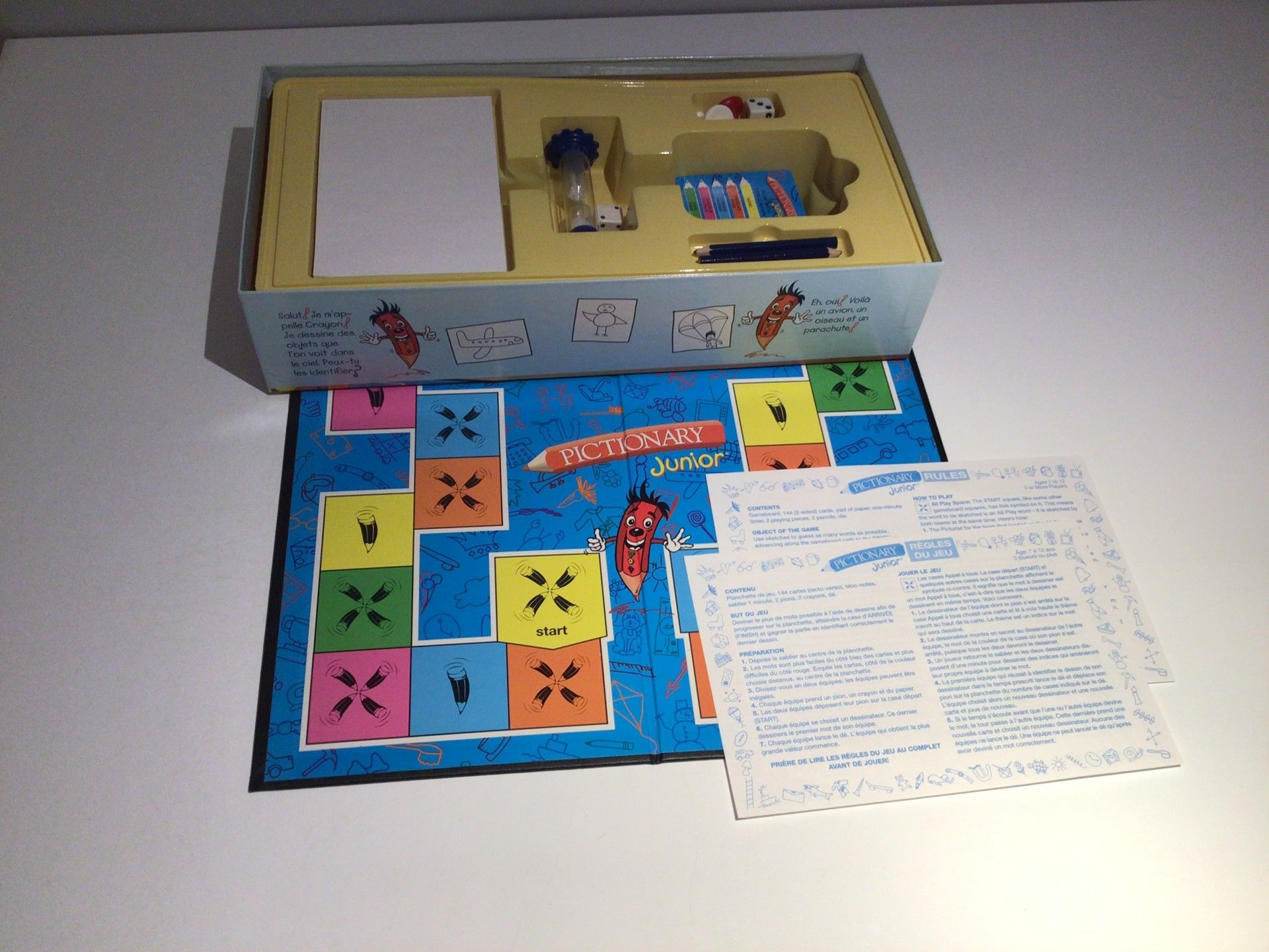Cartes de mots a dessiner et pions du jeu Pictionary.